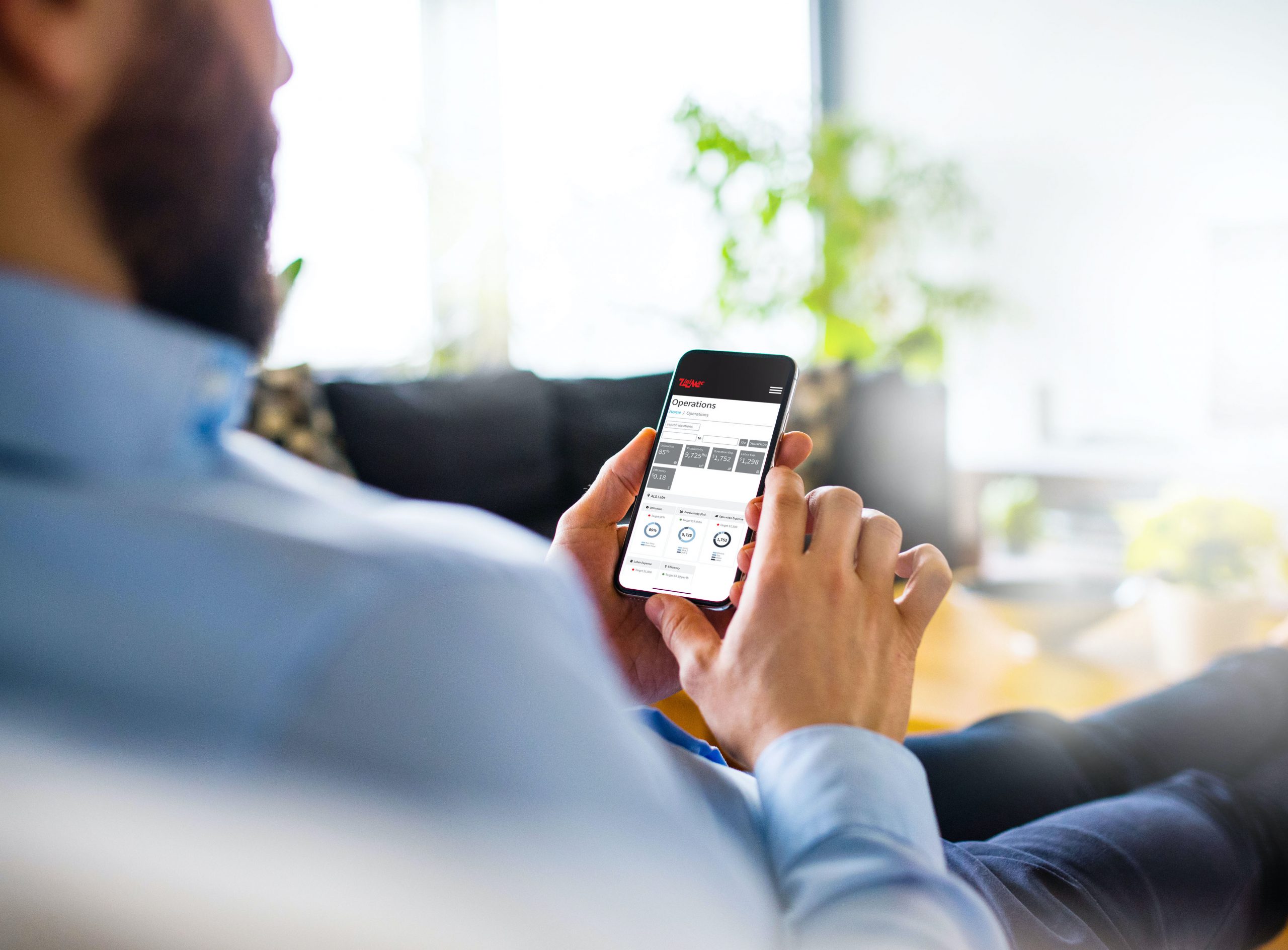 A man holding a smartphone with smart home screen.